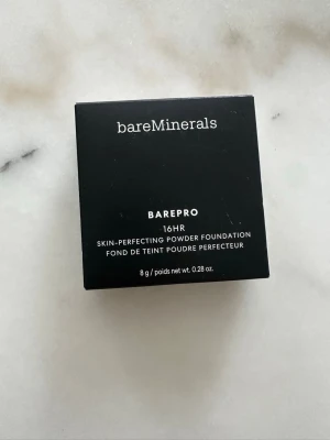 bareMinerals BarePro Powder Foundation - bareMinerals BarePro 16HR Skin-Perfecting Powder Foundation i nyansen Medium Deep 40 Cool. Kompakt puderfoundation i svart förpackning, 8 g. Ger en matt finish och lång hållbarhet. Perfekt för dig som vill ha en naturlig look med sval underton. Oöppnade förpackningar.