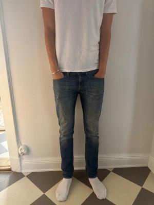 Tiger of Sweden jeans  - Säljer ett par blå slim fit jeans med lätt slitning och klassisk femficksdesign. Jeansen har en smal passform och normal midja, perfekta för en clean och modern look. Materialet är denim med stretch för extra komfort. Modellen är Rex och storleken är 31/34