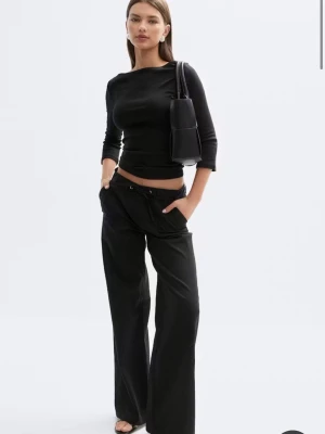 Svart topp med trekvartsärm - Populär svart topp från Gina Tricotmed trekvartsärm och båtringad hals. Modellen är figurnära och enkel.