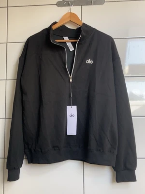 Alo Quarter Zip-black - Helt ny med prislappar kvar, aldrig använd. Säljs eftersom den inte kommer till användning. Skicka gärna ett meddelande om du har frågor eller vill se fler bilder. 😊