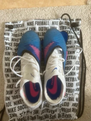 Nike phantom elite - Säljer ett par Nike Phantom Elite i storlek 43. Skorna är använda i cirka 5 träningar och är i bra skick. Skopåse ingår, men ingen box. Obs! Skorna har en liten defekt som jag har sytt eftersom en lagkamrats dobbar rev upp dem. Lagningen påverkar inte hur de fungerar. Nypris: 3 500 kr.