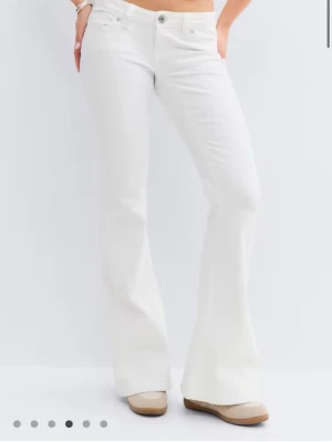 Vita bootcut jeans med låg midja - Vita lågmidjade jeans från Ginatricot med detalj på fickorna, använda några få gånger så väldigt bra skick.