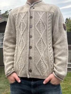 Unik kabelstickad ull kofta - Unik kabelstickad kofta / cardigan med fina detaljer i en fin färg. Perfekt mot hösten och i 70% ull. Storlek S. Fint skick.