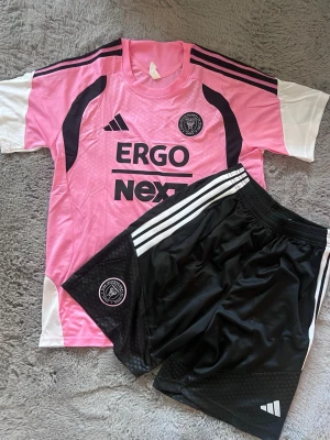 Inter Miami träningsett 26/27 - Ett Inter Miami träningsett 26/27 med T-shirt + shorts med fickor i storlek L 