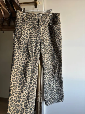 Leopardmönstrade jeans från Gina - Säljer ett par leopardmönstrade jeans från Perfect Jeans i storlek 42. Byxorna har raka ben, klassisk femficksmodell och är tillverkade i ett kraftigare bomullstyg. 