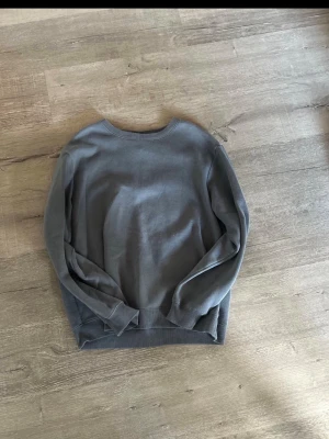 Grå basic sweatshirt - En enkel grå sweatshirt med rund hals och långa ärmar. Tröjan har ribbade muddar vid ärmslut och nederkant. Perfekt för en avslappnad stil och lätt att matcha med andra plagg. Färgen  är mer mot turkos 