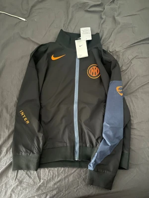 Helt ny svart Inter Nike vindjacka  - svart vattentät vindjacka från Nike med Inter-logga . Jackan är i storlek M  (men är liten i storleken) så det skulle passa som S eller XS,  jag brukar ha M och den var för liten för mig . Helt nytt 