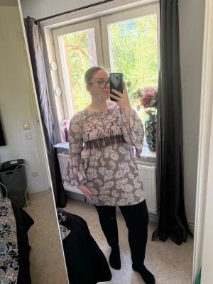 Beige paisleymönstrad tunika med volangärm - Säljer en beige tunika med paisleymönster och vida volangärmar. Blusen har broderade detaljer och en liten knytning vid halsen. Perfekt för dig som gillar boho-stil och vill ha något unikt i garderoben. Från märket Odd Molly i storlek 3 som enligt deras storlekguide motsvarar en storlek L. Jag har vanligtvis en 4/XL. Men denna är något liten på mig. Mycket fint skick, jag hittar inga synliga anmärkningar eller defekter. 