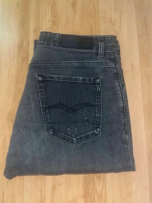 Replay jeans  - Mörkgråa jeans från Replay, modell Marty med slitningar och hål. Jeansens tyg är gjort i Organic Cotton som gör att dem upplevs sköna och bekväma. Midja 39cm, längd 102cm. JAG SKICKAR EJ FLER BILDER NÄR JAG BÄR JEANSEN! för bättre inblick i passformen rekommenderar jag att googla på modellnamnet. För storleksguide kolla måtten noggrant då jeansen alltid kan vara uppsydda heller krympta och jag ej tar emot returer :) (r27)