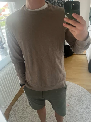 Beige tröja från Dressmann - Säljer en stilren beige tröja från Dressmann i storlek L. Tröjan har rund halsringning, långa ärmar och är tillverkad i mjuk bomull. Perfekt för dig som gillar en enkel och klassisk look. Köpte den för 599