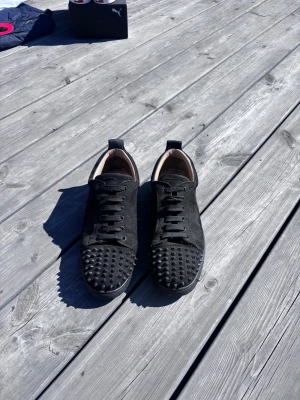 Christian Louboutin  - Säljer ett par svarta Christian Louboutin. Skorna har snörning och är gjorda i mocka material. Perfekta för dig som vill sticka ut med din stil och gillar detaljer som syns. 