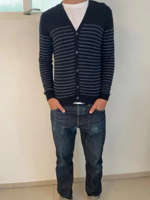 Cardigan från Uniqlo - Riktigt fet cardigan från Uniqlo med schysst passform. Den har långa ärmar, v-ringad hals och ribbade muddar vid ärmslut och nederkant. Perfekt för lager på lager och enkel att matcha med jeans. Det står att den är i storlek L men passar mer som S/M. Hör av dig vid frågor!🙌