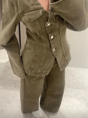 Denim set jeans och jacka - Jeans raka högmidjade storlek 34 , Jacka S. Säljer ett par olivgröna jeans med rak passform och hög midja. Jeansen har tydliga sömmar och är gjorda i ett kraftigt denimtyg. Perfekta för dig som gillar en avslappnad men ändå trendig look.
