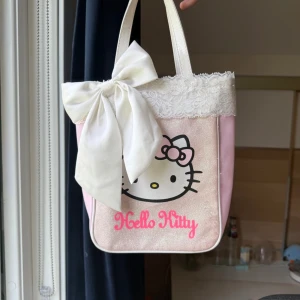 2000s Hello Kitty handväska glittrig med spets tyg och rosett som jag sytt + hello Kitty borste - Säljer en fin rosa 2000s hello Kitty handväska med glitter, spets tyg och med en fin rosett. Jag har sytt på spets tyget och rosetten själv! Man får även med hello Kitty borsten som syns på de sista bilderna. Bra kvalitet på båda! 💓