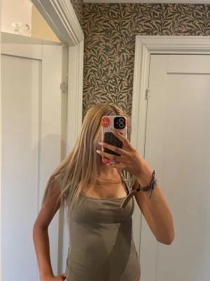 Beige ribbad linnetopp - Säljer en beige ribbad linnetopp med smala axelband och fyrkantig ringning. Toppen är figurnära och perfekt för att styla med jeans eller kjol. Enkel och stilren design som passar till många olika looks.