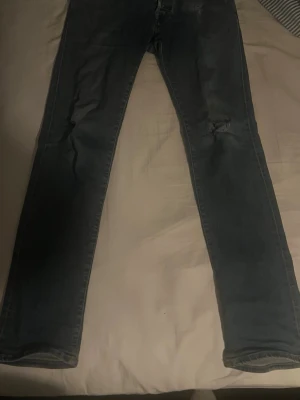 Mörkblå raka jeans med slitning - Blåa Jacob Cohen jeans Limited edition 110/404.Storlek 33 // model 622 // midja 44cm längd 104cm innerbens längd 80cm mycket bra skick har ett litet hål vid knät som jag fixat så att dem ser lite använda ut och får lite detalj // skriv vid minsta lilla fundering eller fråga och pris kan diskuteras👍😊