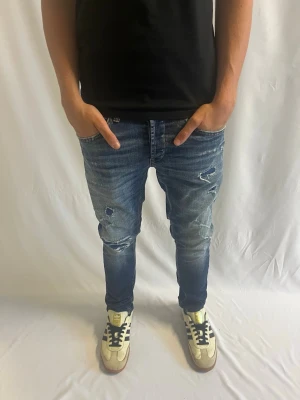 Dondup George | storlek 31 - Tja! Säljer nu dessa blå Dondup George med feta slitningar.                                                                   Inga defekter - Storlek 31 - pris - 749kr.              Mått: längd 98 cm, midja 38 cm.                         Hör gärna av er vid intresse eller frågor! 