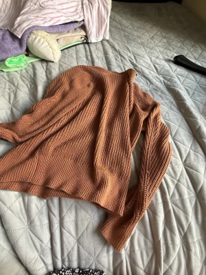 Brun stickad tröja från Lindex - Säljer en brun stickad tröja från Lindex i storlek M. Tröjan har en avslappnad passform, ribbade muddar och är tillverkad i ett mjukt, grovstickat material. Perfekt för lager på lager och höstmys.