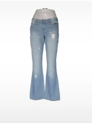 Ljusblå bootcut jeans med slitningar - Säljer ett par ljusblå bootcut jeans med slitna detaljer och utsvängda ben. Jeansen har klassiska fem fickor, dragkedja och knapp framtill samt dekorativa sömmar på bakfickorna. Tillverkade i denim med en skön passform💓