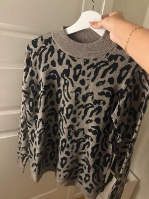Beige leopardmönstrad stickad tröja - Säljer en beige stickad tröja med svart leopardmönster. 
