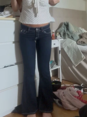 Mörkblå bootcut jeans  - Säljer ett par mörkblå bootcut jeans med sömmar. Lågmidjade!!!! Vit och röda sömnar! Pris kan diskuteras! Storlek 164 men passar xs