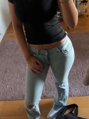 Ljusblå jeans från Nelly  - Säljer ett par ljusblå jeans med raka ben och slitningar vid knäna. Från Nelly storlek 34