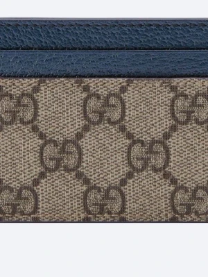 Beige och blått GG-mönstrat bälte - Snyggt bälte i beige med klassiskt GG-mönster och blåa detaljer. Bältet har en stilren design med mörkblå kant och GG-logga i metall. Perfekt accessoar för att lyfta din outfit.