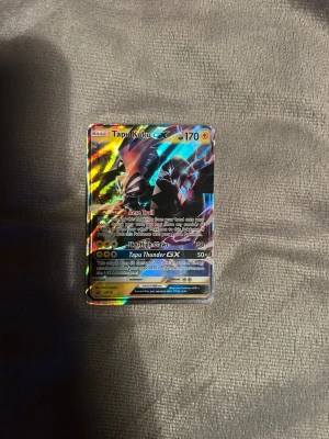 Tapu Koko GX Pokémonkort - Säljer ett Tapu Koko GX Pokémonkort med holografisk yta och färgstarka detaljer. Kortet har 170 HP och flera attacker som Aero Trail, Sky-High Claws och Tapu Thunder GX. Perfekt för samlare eller Pokémonfans.