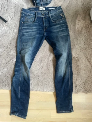 Blå slim fit jeans från Replay - Snygga blå slim fit jeans från Replay med slitningar och tvättade detaljer. Nästan nya