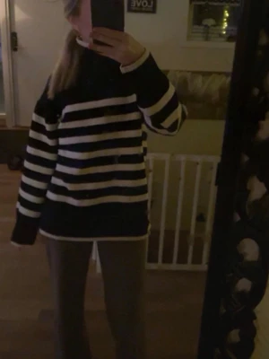 Svartvit randig oversized tröja - Säljer en oversized tröja med breda svarta och vita horisontella ränder. Tröjan har långa ärmar och en avslappnad passform med ribbade muddar vid ärmslut och nederkant. Perfekt för en chill och trendig look.