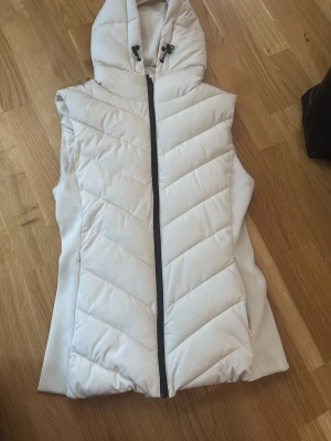 Vit dunväst med huva och dragkedja - Storlek S för liten för mig så säljer billigt för att bli av med den ej använd pga att den är för liten