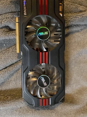 ASUS grafikkort med dubbla fläktar - Säljer ett ASUS grafikkort med två stora kylfläktar och svart hölje med röda detaljer. Kortet har flera DVI-portar för anslutning till skärmar. Perfekt för dig som vill uppgradera din dator med extra grafikprestanda.
