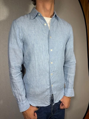 Uniqlo Linné skjorta XS - Hej och välkommen till byTorén. Detta är en Linné skjorta från Uniqlo i storlek XS med normal passform. Modell på bild är ca 182, 67kg. Plagget är i bra skick utan några defekter. Tveka inte på att höra av dig, även om det skulle vara minsta lilla;)