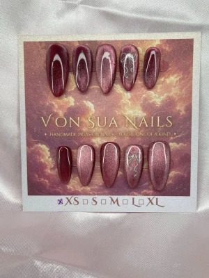 Satin (XS);Medium Almond - Handgjorda press-on naglar i vinröd jelly-cateye med en medium lång almondform. Två av naglarna har vita rosetter för en unik look. Snygg glansig finish och passar perfekt för dig som vill ha något extra till naglarna.XS: 14 mm, 11 mm, 11,5 mm, 10 mm, 8 mm