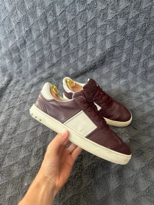 Vinröda valentino flycrews - Ett par feta valentino flycrews i storlek 42. De är använda men fortfarandes i bra skick. 6.8/10✅. Det ända problemet är den lilla skrapan på tån som man ser i bild 2 och två nitar som är borta på vänster sko och en på höger sko. Hör av dig om du har några frågor priset är inte satt i sten!