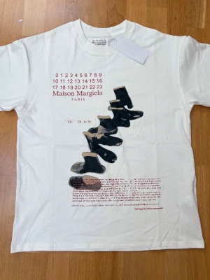 Maison Margiela vit t-shirt med tryck - Vit t-shirt från Maison Margiela med tryck framtill. Helt ny och oanvänd.