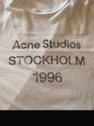 Vit långärmad t-shirt Acne Studios - Vit långärmad t-shirt från Acne Studios i mjuk bomullsblandning med 16% hampa. Enkel och clean design med rund hals och normal passform. Perfekt basplagg för alla tillfällen och lätt att matcha med andra plagg. Kvitto finns!!