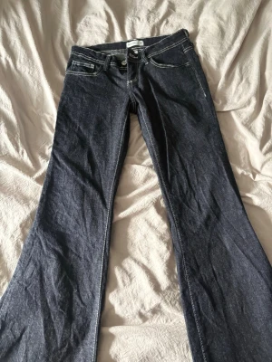 Mörkblå bootcut jeans med kontrastsömmar - Snygga mörkblå bootcut jeans med vita kontrastsömmar. Tyvärr försmå använt 1 gång