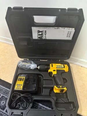 Dewalt borrskruvdragare i väska - Säljer en Dewalt borrskruvdragare i svart och gul plast med ergonomiskt handtag. Medföljer laddare, batteri och manual, allt i en praktisk hård plastväska. Perfekt för hemmafixaren som vill ha ett pålitligt verktyg till hands.