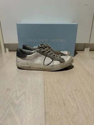 Philippe Model vita sneakers - Säljer ett par phillipe model sneakers med en klassisk design. Skorna är synligt använda. Box ingår. Priset är ej hugget i sten