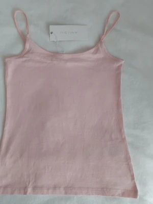 Ljusrosa linnetopp från Amisu - Säljer en enkel och stilren ljusrosa linnetopp från Amisu. Toppen har tunna reglerbara axelband och är tillverkad i mjuk bomull. 