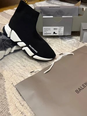 Balenciaga Speed sneaker - Svarta Balenciaga Speed Trainer sneakers med vit chunky sula och stickad ovandel i stretchigt material. Strumpmodell med logga på sidan och futuristisk design. Perfekta för dig som gillar streetwear och vill ha något som sticker ut. Helt ny finns i alla storlek .