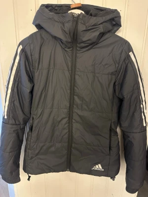 Svart pufferjacka från Adidas - Tunnare dunjacka.
