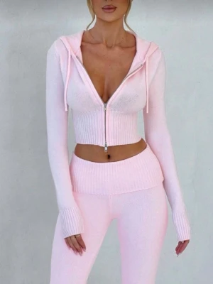 Ljusrosa ribbat loungewear  - Supermysigt loungewear i ljusrosa med croppad hoodie och dragkedja framtill. Hoodien har långa ärmar, ribbade muddar och matchande höga tights. Perfekt för chill hemma eller softa dagar. Materialet är stickat och stretchigt för extra komfort.