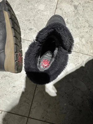 Svarta vinterstövlar från Softwalk - Säljer ett par svarta vinterstövlar från Softwalk med mjukt, fluffigt foder och robust sula med röda detaljer. Stövlarna har dragkedja på sidan och är perfekta för kalla dagar. Klassisk design med bekväm passform och slitstarkt material.