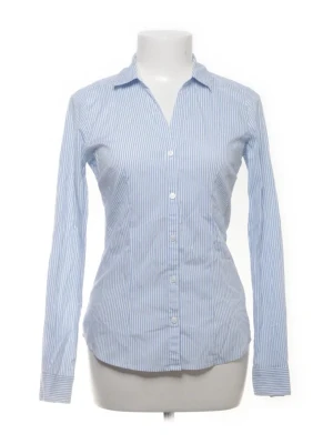 Blåvit randig skjorta med knappar - Klassisk blåvit randig skjorta med lång ärm och knäppning framtill. Tajt i midjan, supertrendig och perfekt till våren <3 aldrig använd!