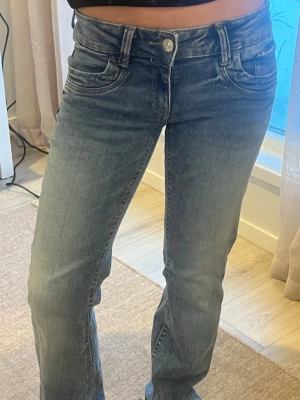 Blå bootcut jeans med slitningar - Säljer ett par blå bootcut jeans 