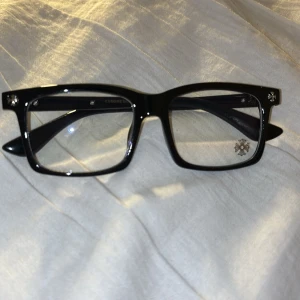 Chrome heart glasögon - Snygga svarta solglasögon med breda bågar och fyrkantig form. Klassisk design som passar till många stilar. Perfekta för att ge en cool touch till din outfit.