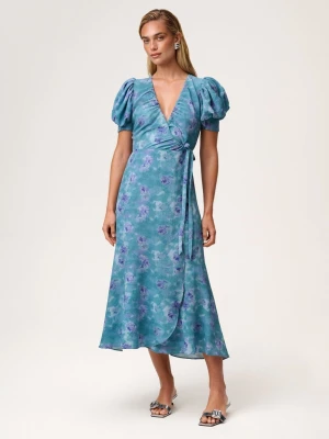 Adoore klänning blå strl 36 - Snygg blå omlottklänning med lila blommönster och puffärmar. Djup v-ringning och knyt i midjan ger en feminin siluett. Lätt, flowigt material som känns luftigt och bekvämt. Perfekt för dig som gillar trendiga och romantiska plagg. Helt ny med tags! Nypris: 1695kr