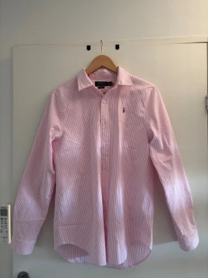 Rosa och vit randig skjorta Polo Ralph Lauren - Riktigt fräsch skjorta från Ralph Lauren i nyskick, storlek M.